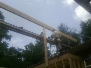 Carpenter setting a ridge beam over a new addition frame — Ice Dam Removal by Roofing Brothers in Shannon City