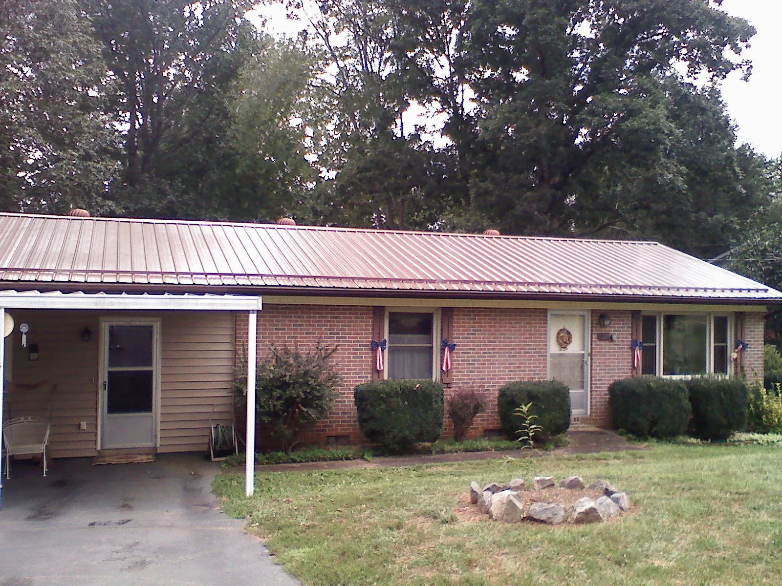 Bronze metal roof and carport on a brick ranch home — Roof Repair work by our crew in Shannon City